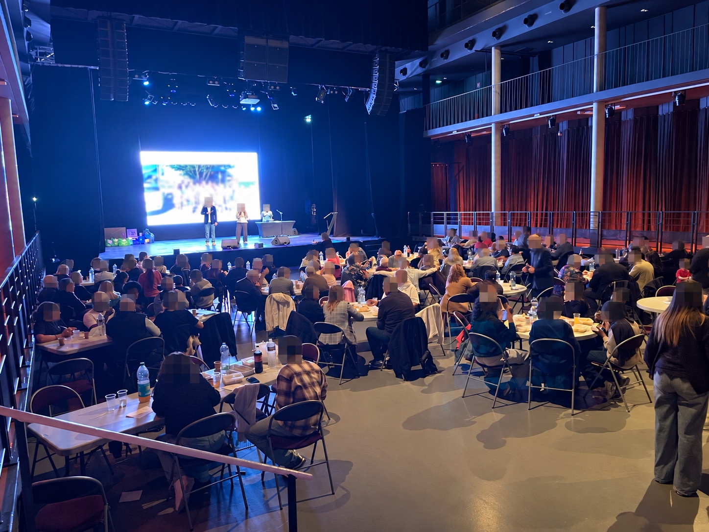 Vue de la salle et des tables pendant le spectacle. Des visages sont masqués.